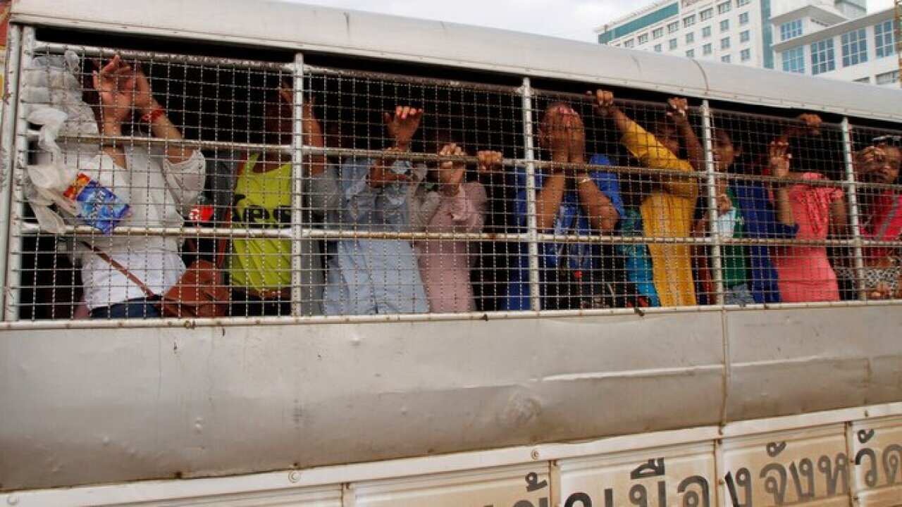 Cambodian migrant workers stand in a Thai police truck