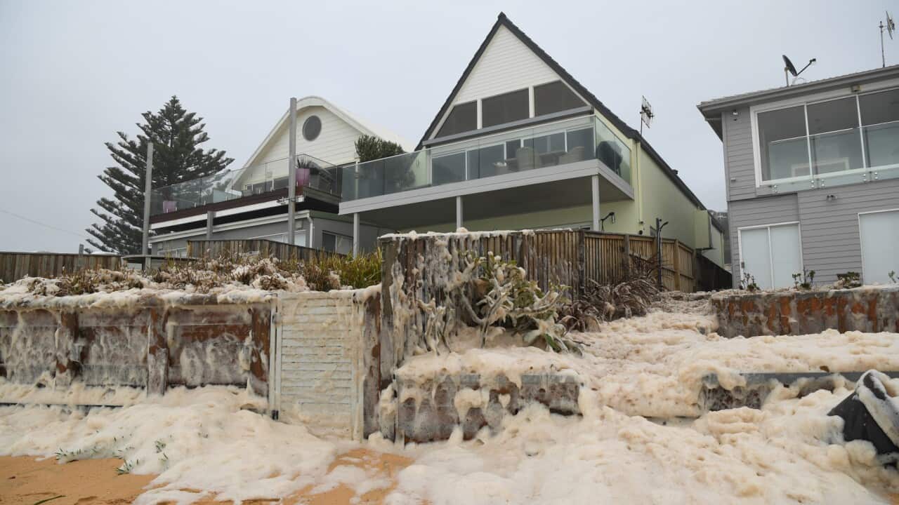Sea foam approaching beachfront houses after heavy rain and storms at Collaroy in Sydney's Northern Beaches