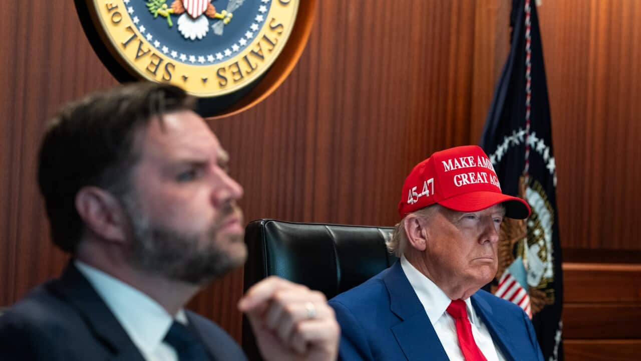 JD Vance and Donald Trump sitting on chairs next to each other.