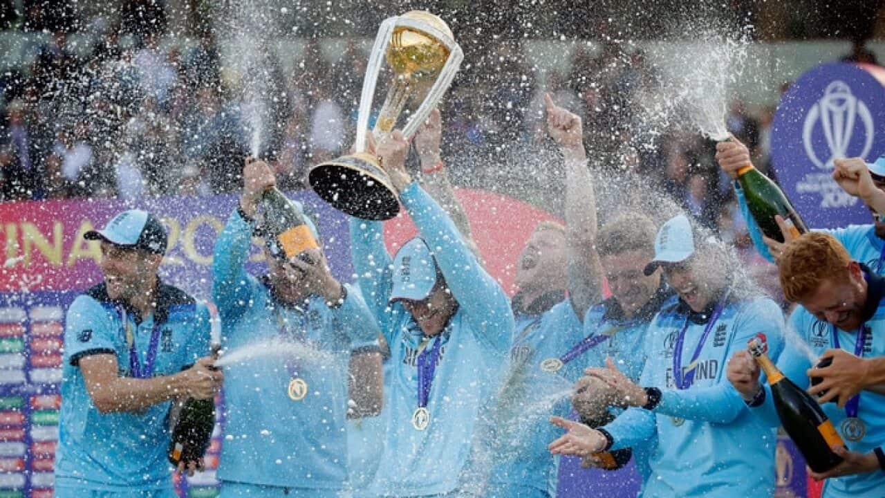 England's captain Eoin Morgan is doused in champagne as he raises the trophy after winning the Cricket World Cup