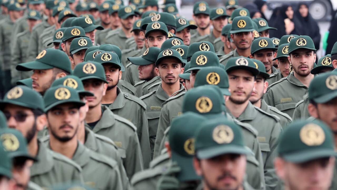 A large group of soldiers wearing green uniforms and green caps lining up.