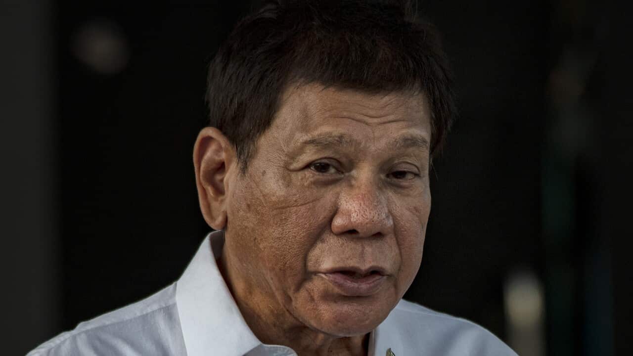 Rodrigo Duterte, wearing a white shirt, with a muted expression.