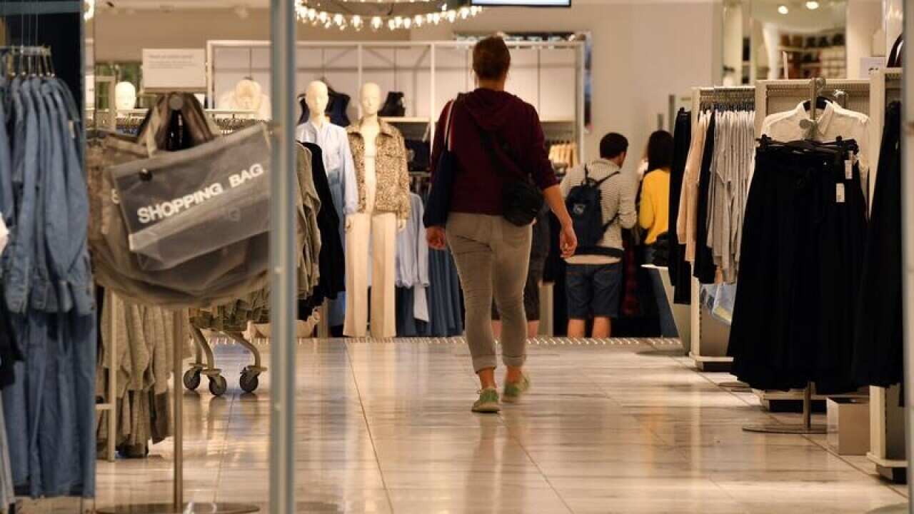 A shopper walks in a women's fashion store
