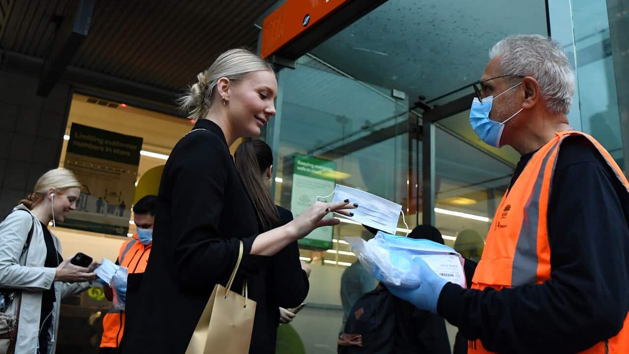 NSW Transport workers hand out face masks at Town Hall rail station in Sydney, Thursday, May 6, 2021. In Sydney, the Blue Mountains, the Central Coast and Illawarra, masks will be compulsory at all public indoor venues and on public transport from 5pm on