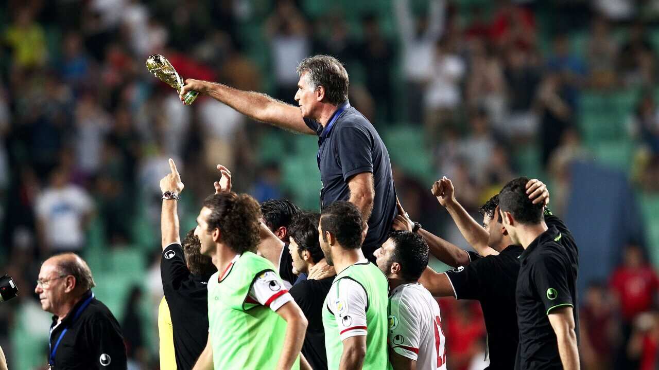 Iran's Portuguese coach Carlos Queiroz (up) celebrates after the 2014 FIFA World Cup qualifying soccer match between South Korea and Iran. (EPA)