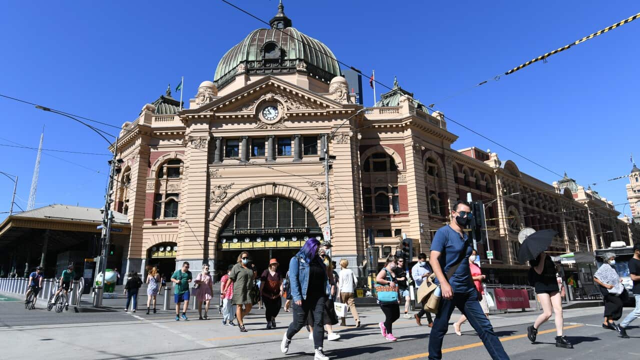 People cross at the intersection in front of Flinders Street station in Melbourne.