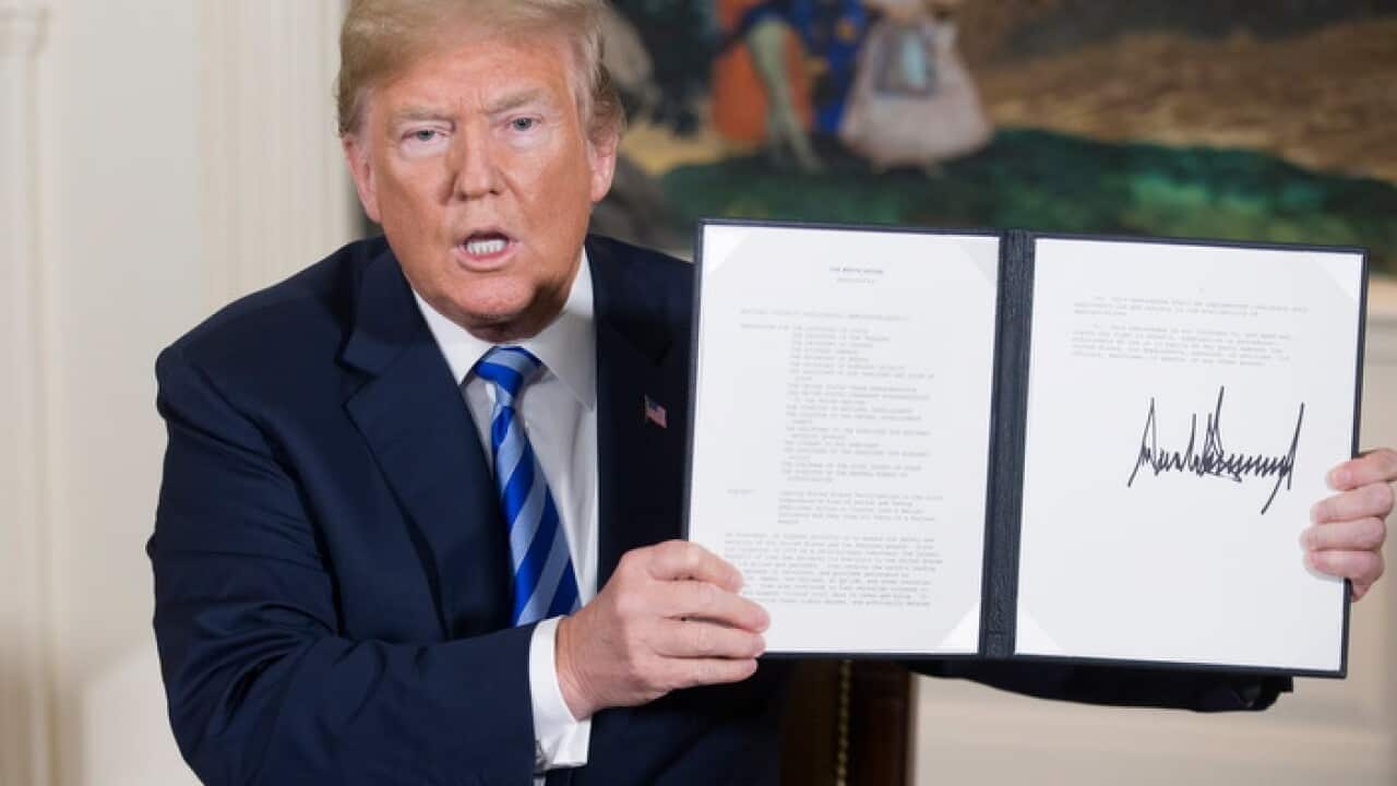 US President Donald J. Trump holds up a national security presidential memorandum on Iran.