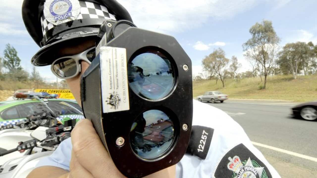 A police officer monitors traffic with radar at the launch of the nation wide police campaign RAID in Canberra, Friday, Nov 21, 2008. RAID (Remove All Impaired Drivers) is aimed at detecting and removing all alcohol and/or drug affected drivers from the n