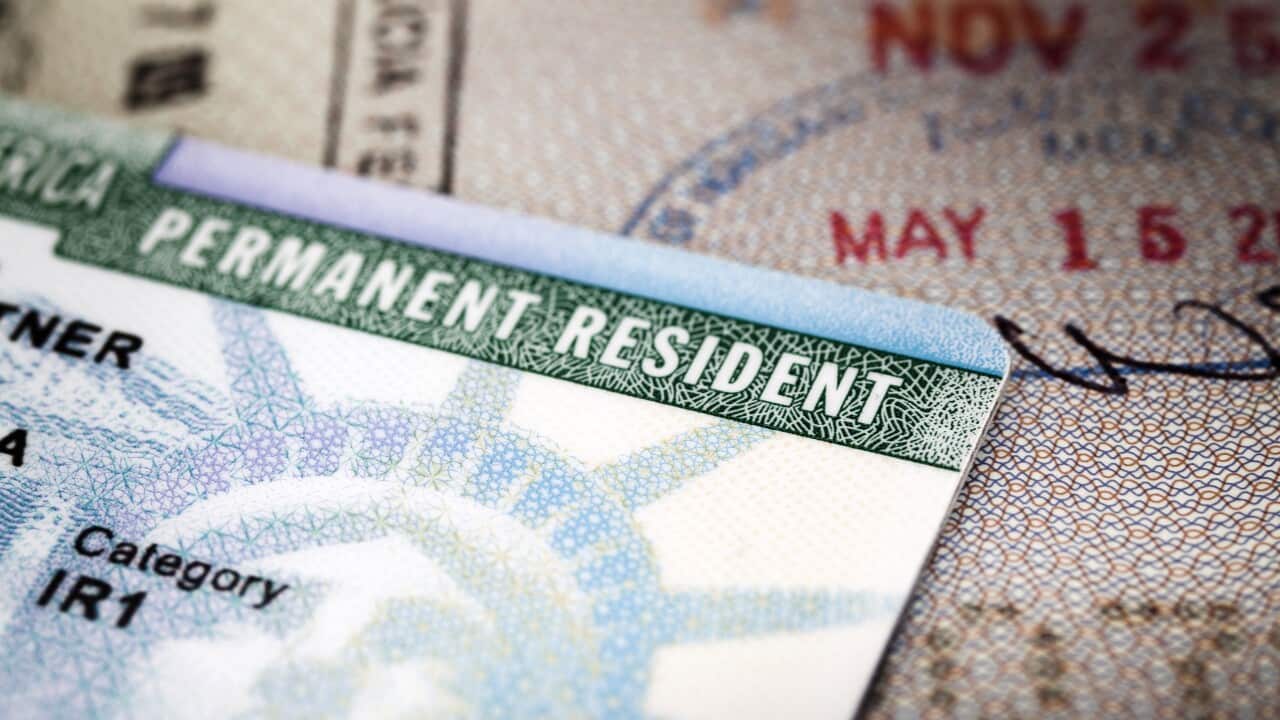 A Green Card lying on an open passport, close-up, full frame