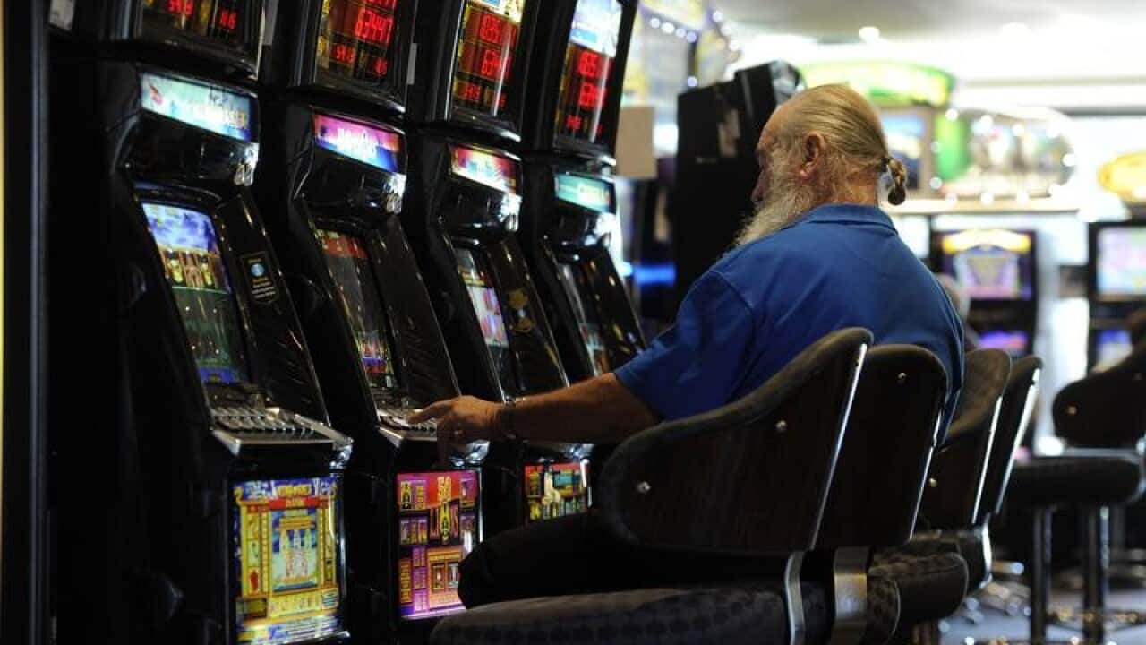 A file image of a man playing poker machines at a club