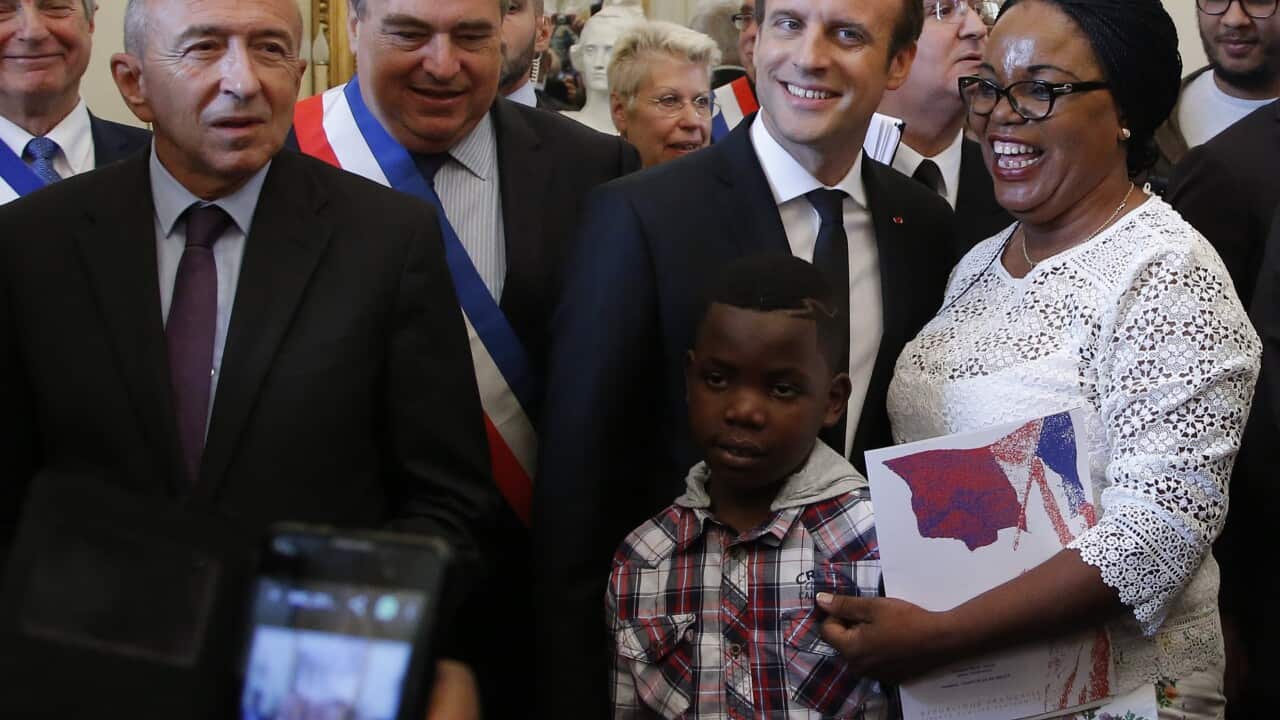 French President Emmanuel Macron, poses with new  French citizens during a citizenship ceremony.