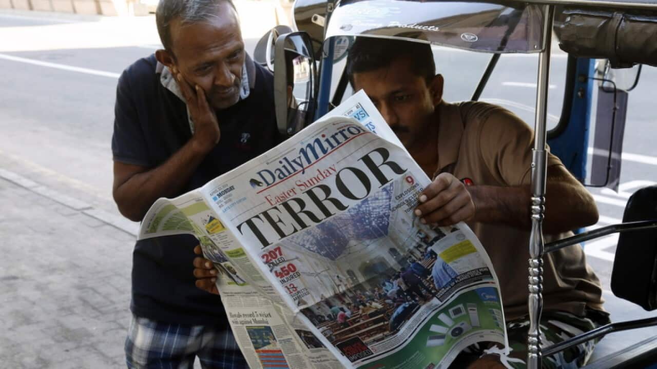 People read a newspaper the day after multiple blasts killed hundreds Sri Lanka,