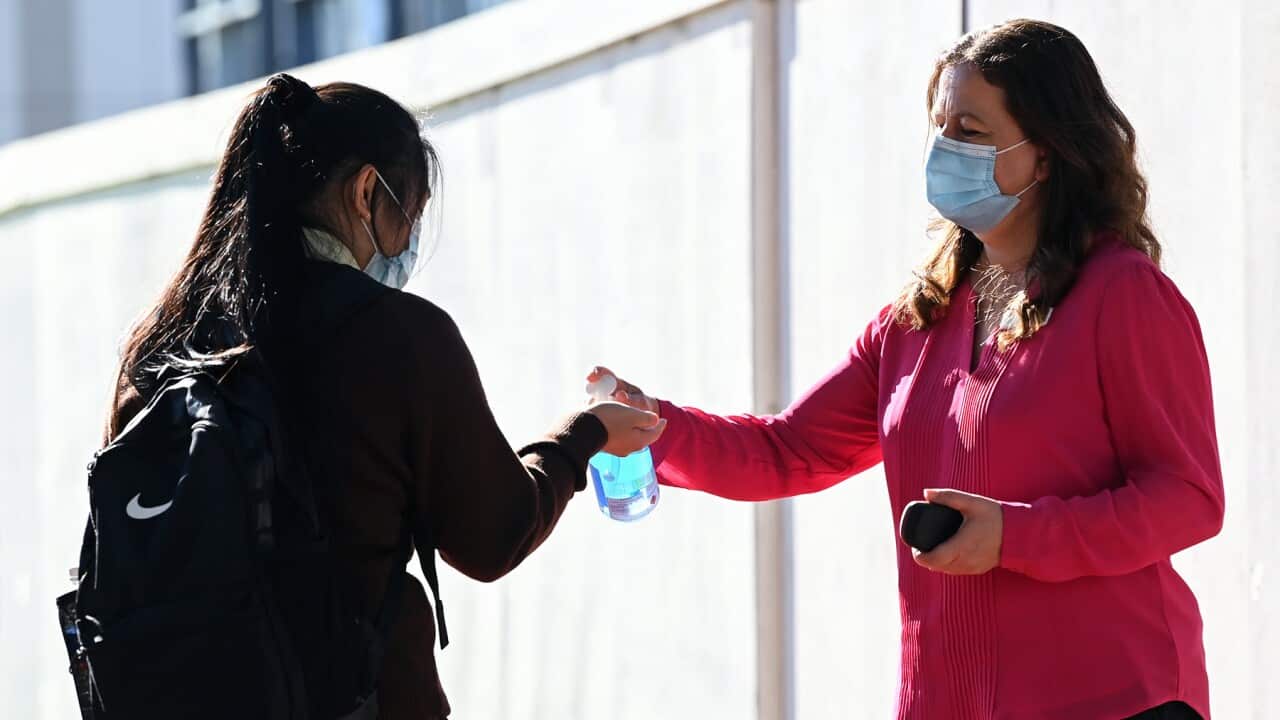 Student applies hand sanitiser in NSW