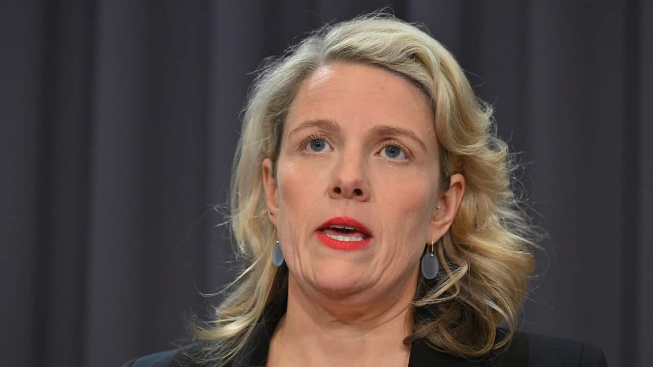 A woman in a black blazer.