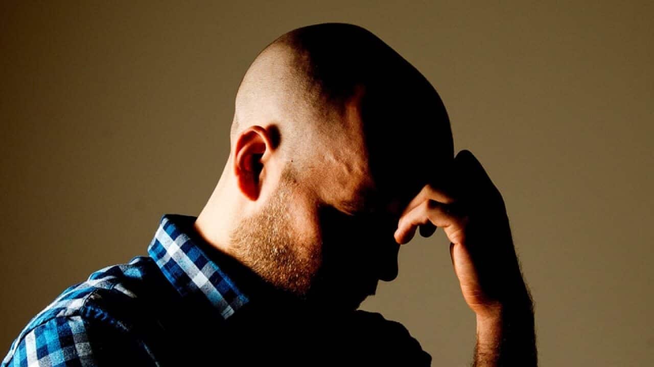 a man with his hand on his head