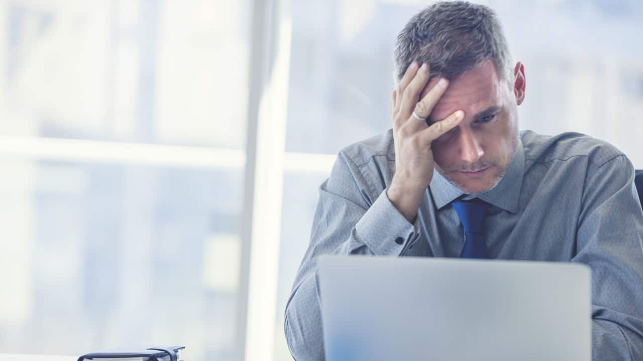 Stressed mature businessman with laptop.