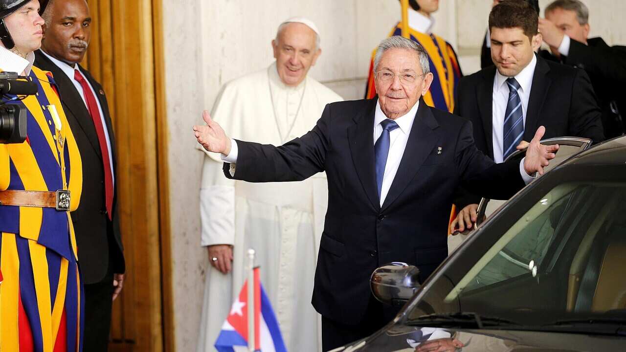Cuban President Raul Castro waves as Pope Francis, background, looks at him (Fabio Frustaci/ANSA via AP)