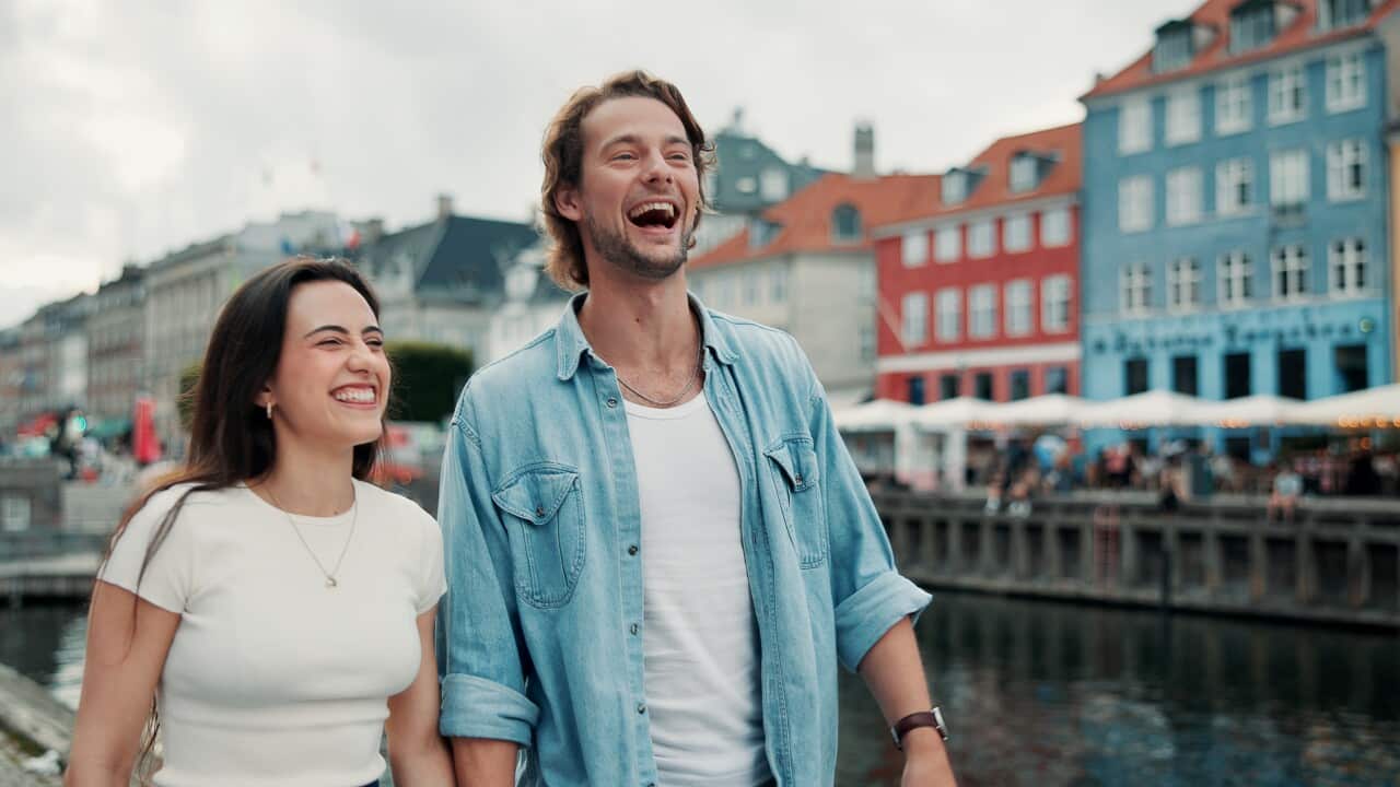 Travel, happy and couple by harbor walking for sightseeing on holiday, vacation and laugh outdoor. Dating, holding hands and man and woman for bonding, funny joke and talking for tourist destination