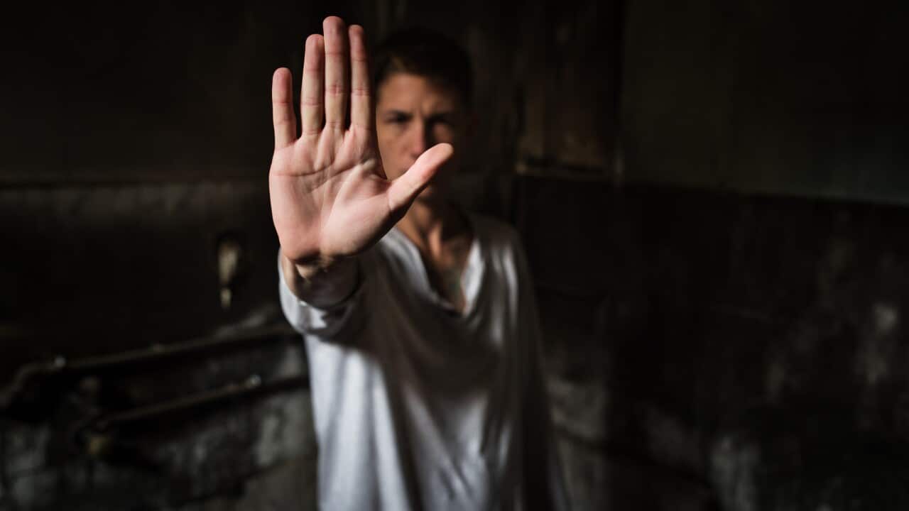 Young man showing STOP sign with his palm