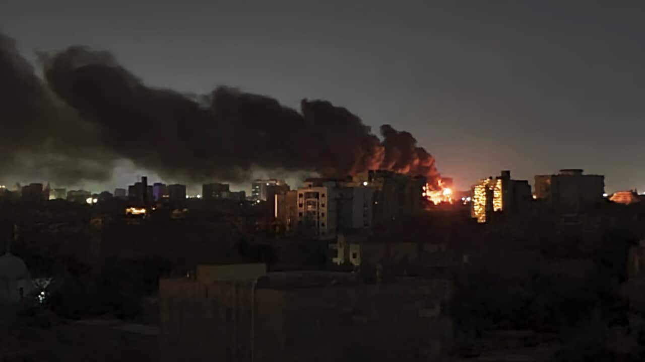 Smoke rises over the horizon as a fire burns after a strike in Khartoum