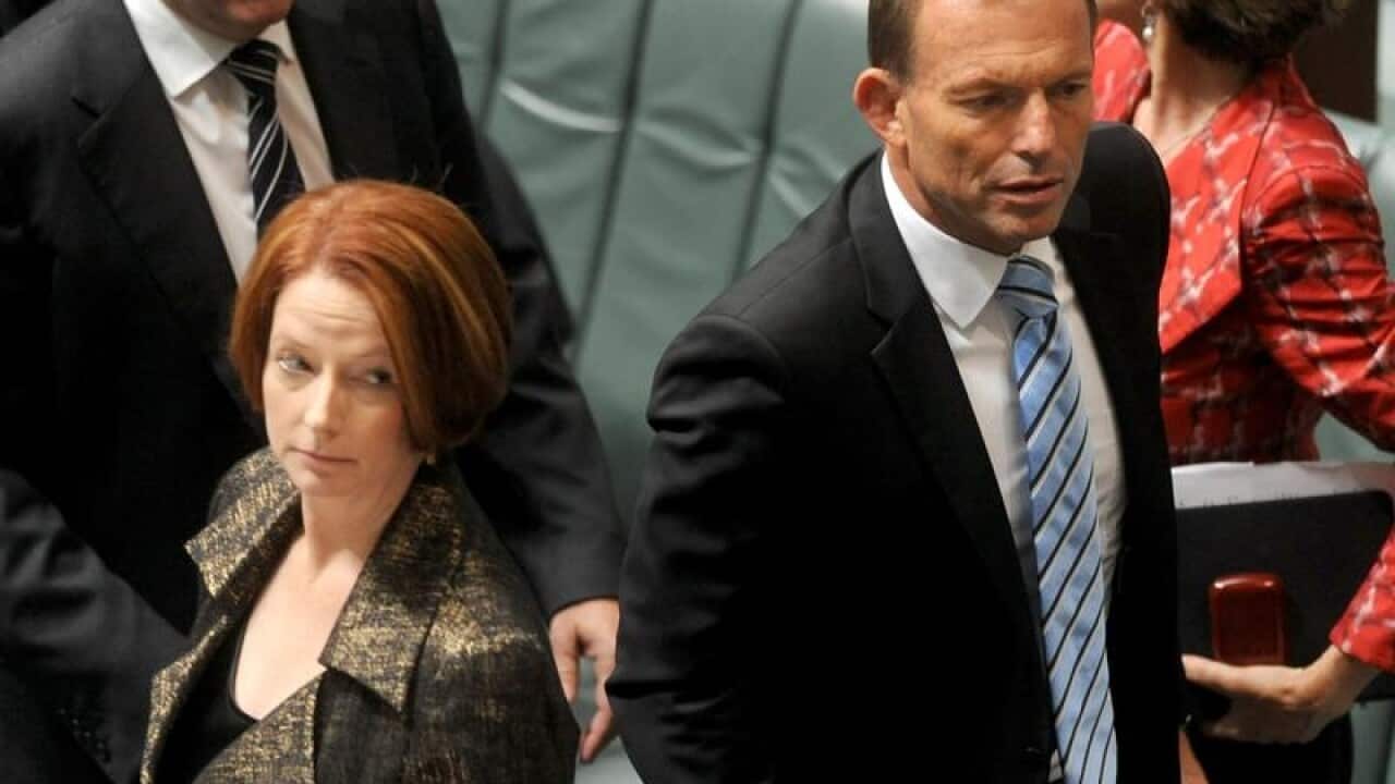 Tony Abbott walks behind Julia Gillard during question time in 2012.