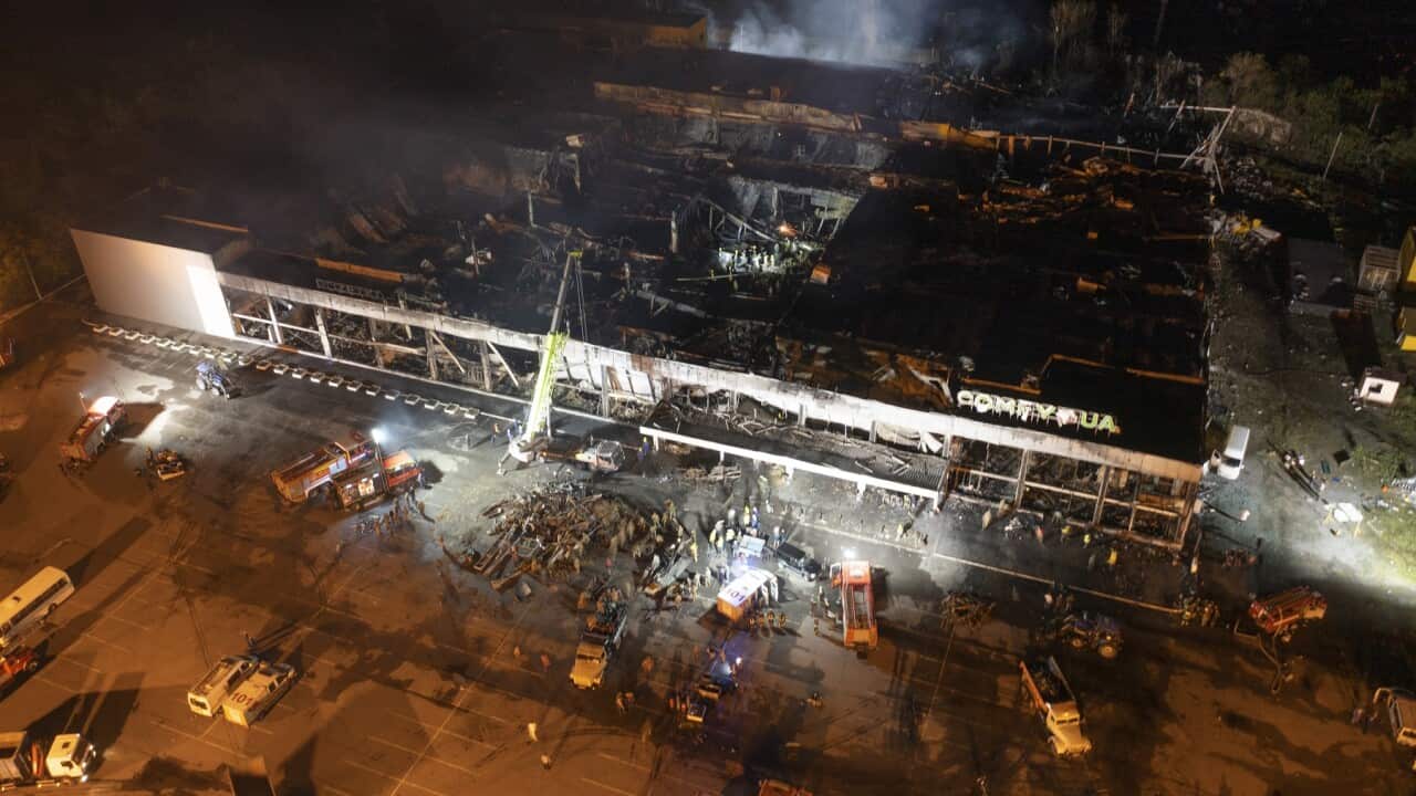 Firefighters work to extinguish a fire at a shopping centre after a rocket attack in Kremenchuk