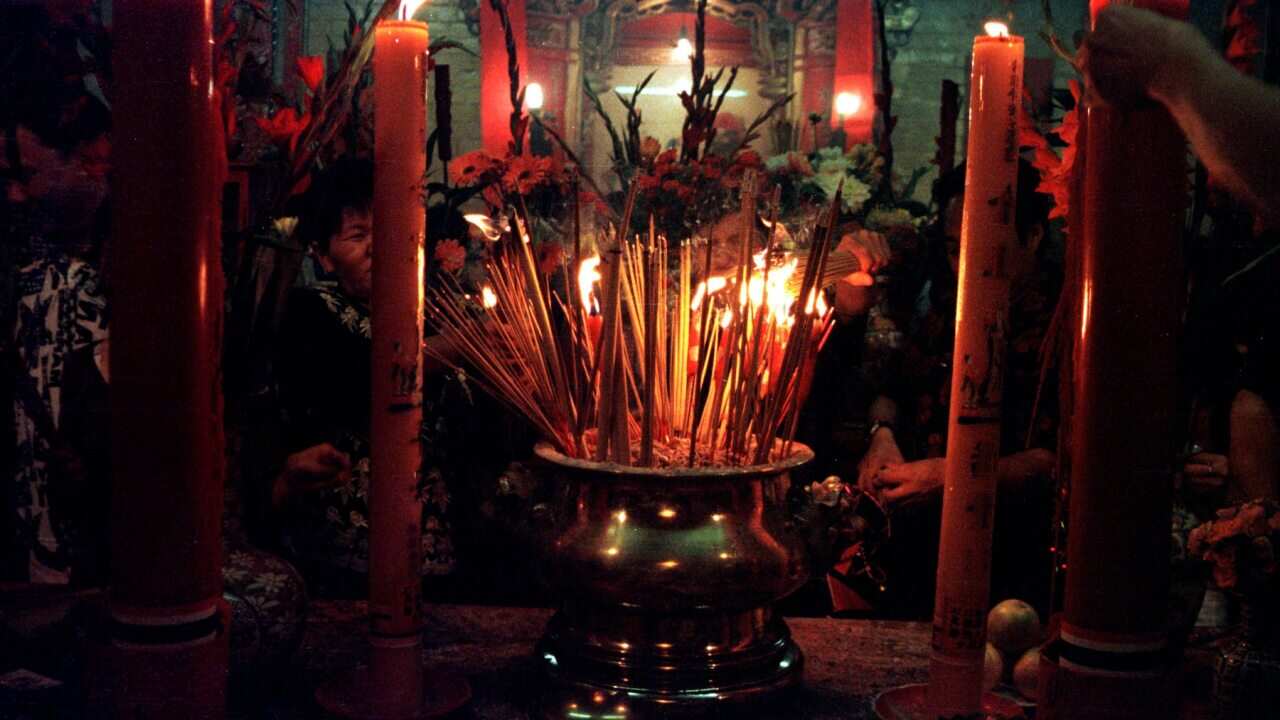 Prayers are offered with incense sticks at the Glebe Buddhist Temple in Sydney
