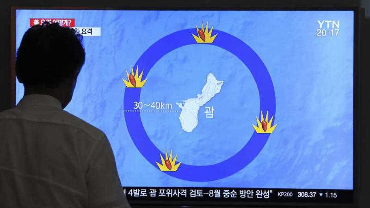 A South Korean man watches a TV screen showing a local news program reporting on North Korea's threats to strike Guam with ballistic missiles