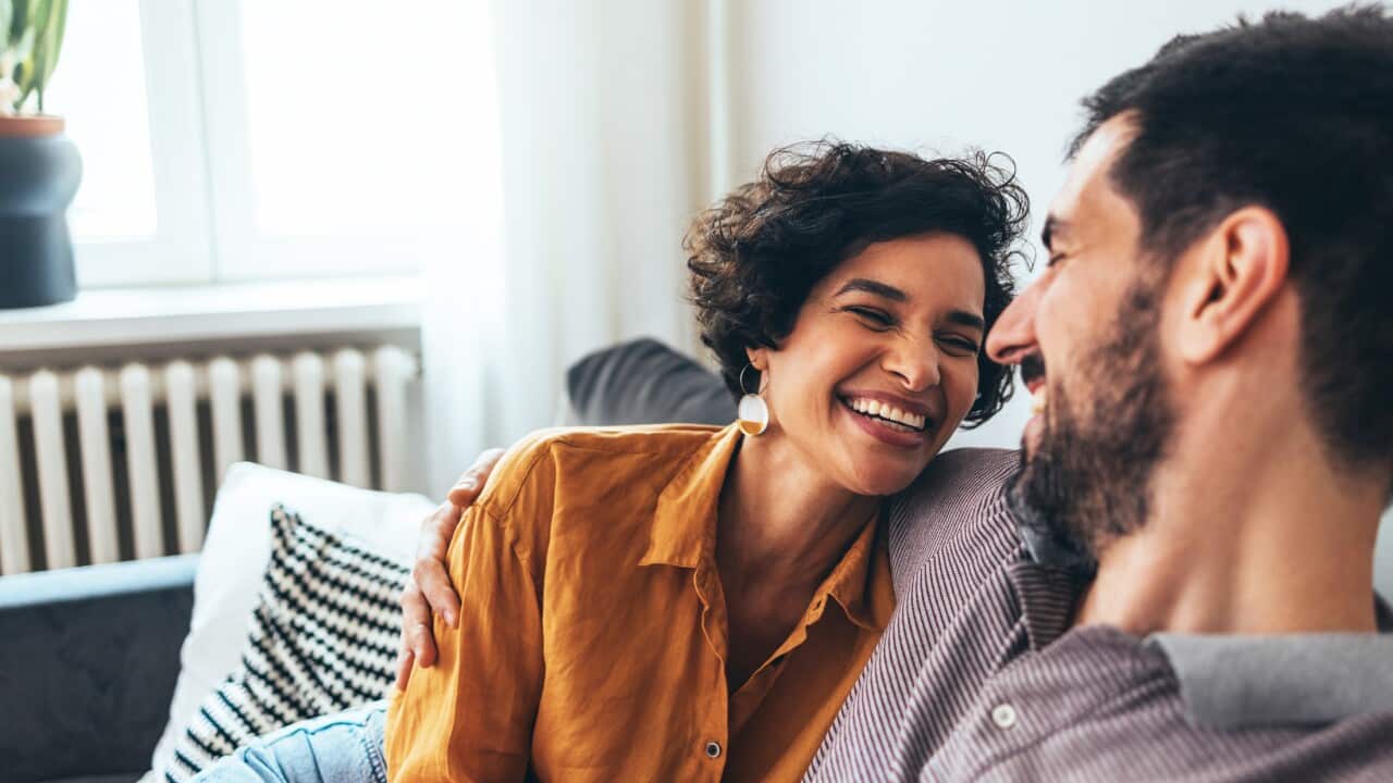 A Happy Beautiful Couple Sitting On The Cozy Sofa And Enjoying Spending Their Leisure Time Together