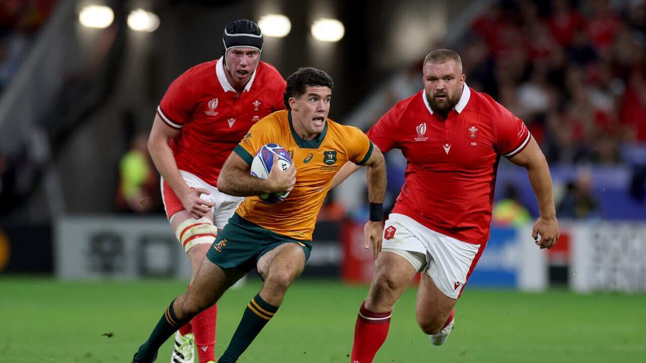 Australia's Ben Donaldson (centre) breaks away from Wales' Adam Beard (left) and Wales' Tomas Francis during the Rugby World Cup 2023, Pool C match at the OL Stadium in Lyon, France. Picture date: Sunday September 24, 2023.. See PA story RUGBYU World Cup Wales. Photo credit should read: Bradley Collyer/PA Wire. RESTRICTIONS: Use subject to restrictions. Editorial use only, no commercial use without prior consent from rights holder.