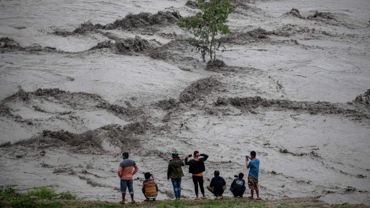 People watch the flooded Melamchi river following torrential rains in Melamchi, Sindhupalchwok district, Nepal, 16 June 2021.