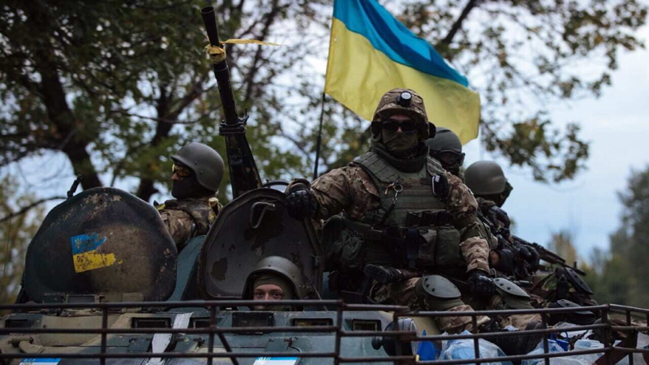 Ukrainian soldiers drive in an APC.