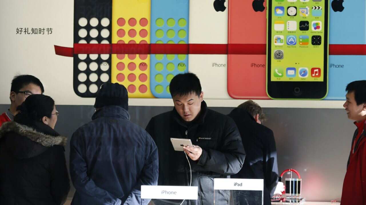 Customers view products at an Apple Store in Beijing