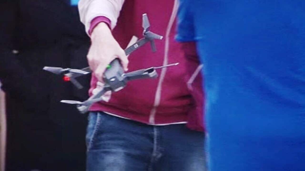 James Ashby holding a drone after the flight above Parliament House