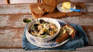 Seafood chowder in a bowl, with buttered brown soda bread.