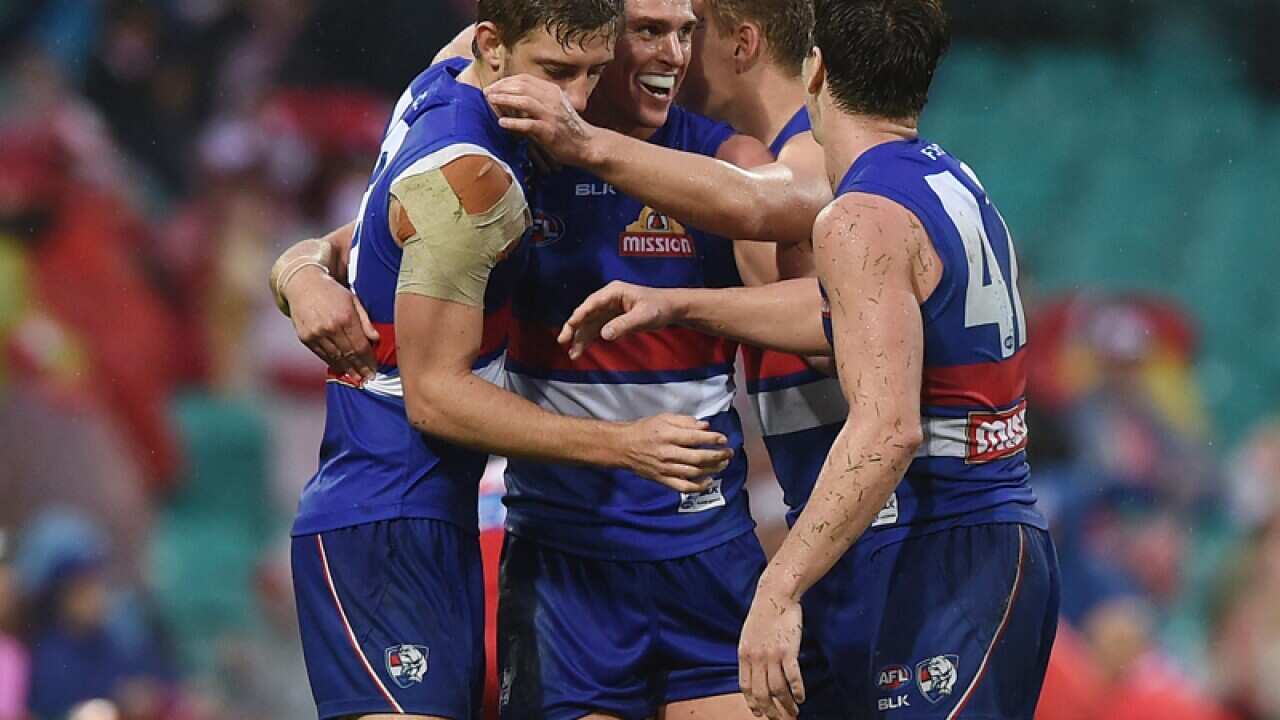 Bulldogs players celebrate their win over the Swans.