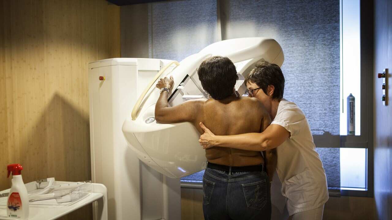A technician carries out a routine mammogram