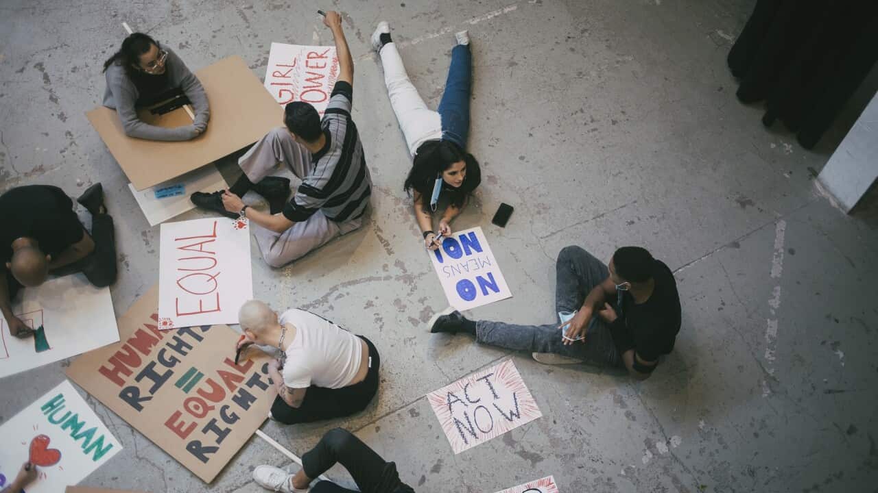 High angle view of female and male protestor preparing signboards for human rights
