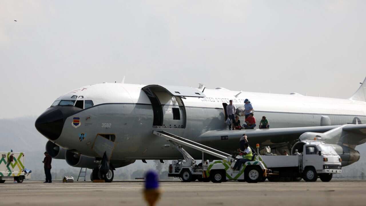 Members of of the US Air Force stand on a Boeing 707 aircraft