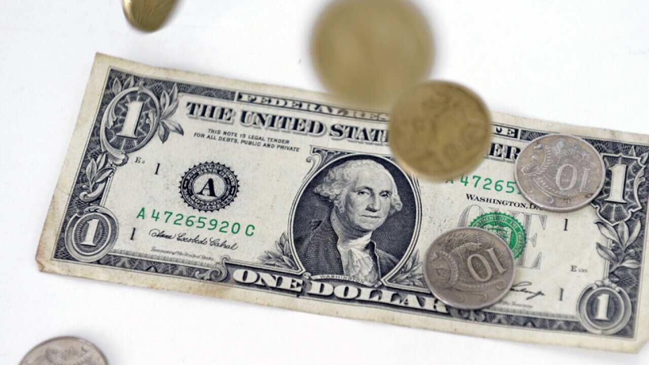 Australian Dollar coins fall onto a 1 US Dollar note