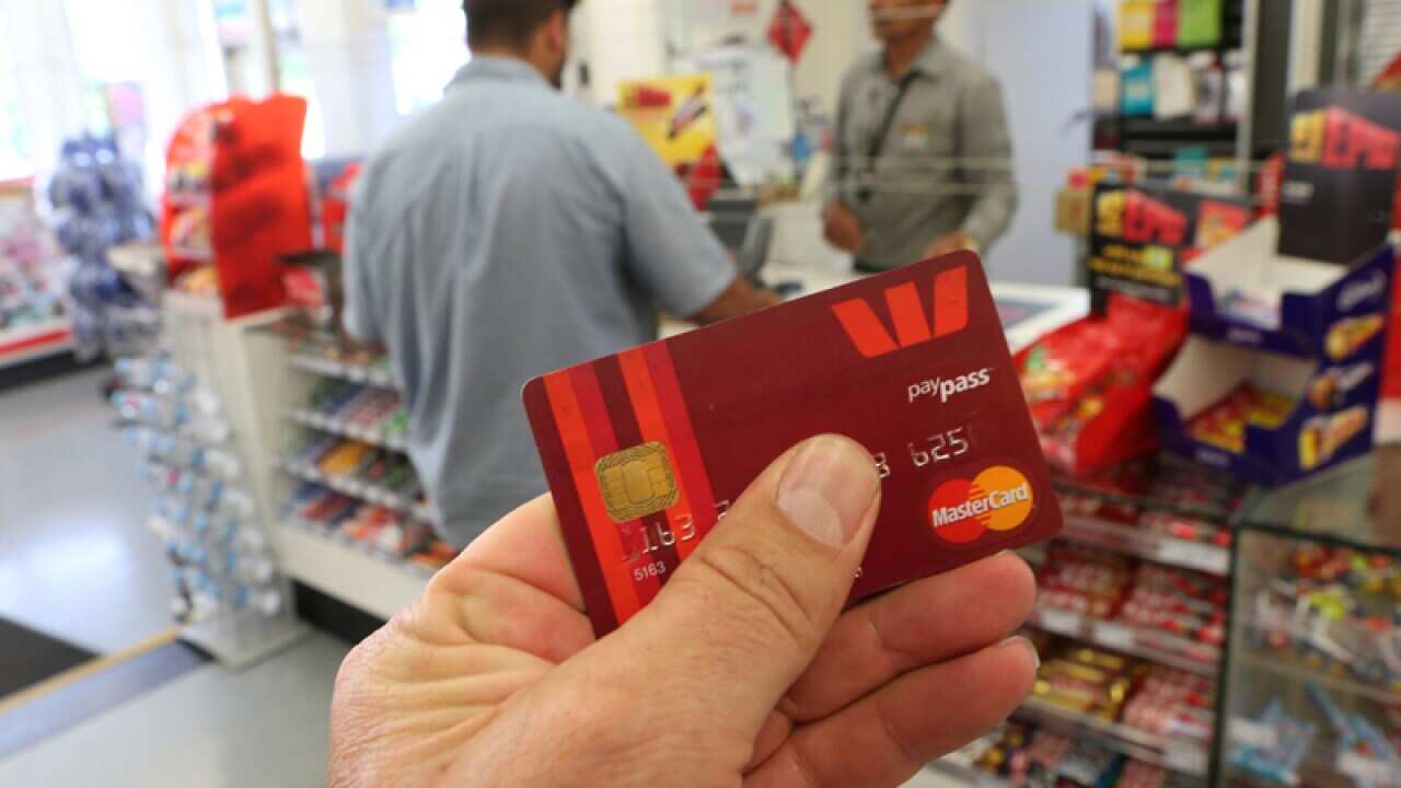 A customer using a tap-and-go credit card in a store
