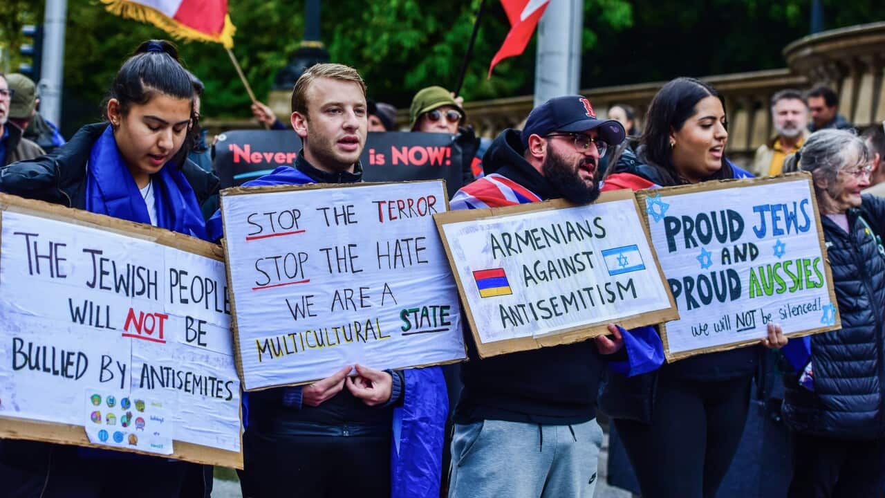 Pro-Jewish supporters hold placards at a “Never Again Is Now“ rally