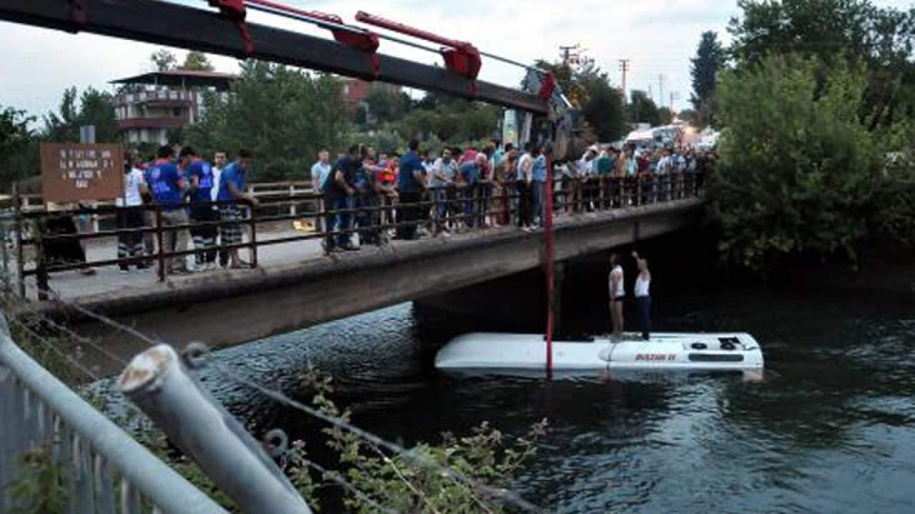 Turkish rescuers lift a bus from a canal near Osmaniye