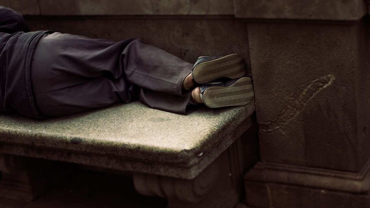 Homeless person sleeping on a bench