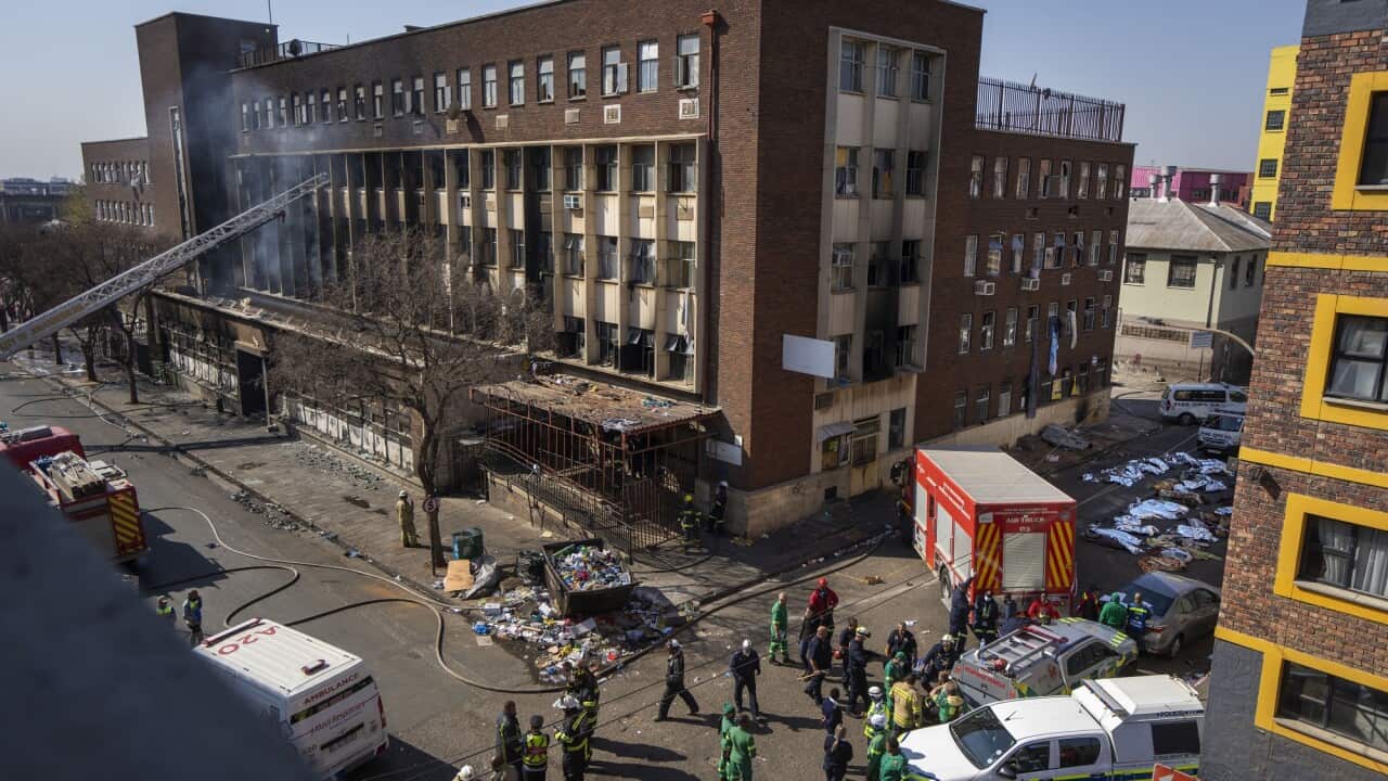Firefighters are pictured on the street outside the destroyed apartment building.