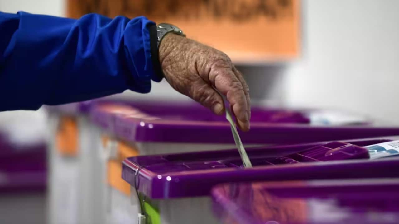 Person putting vote in ballot box