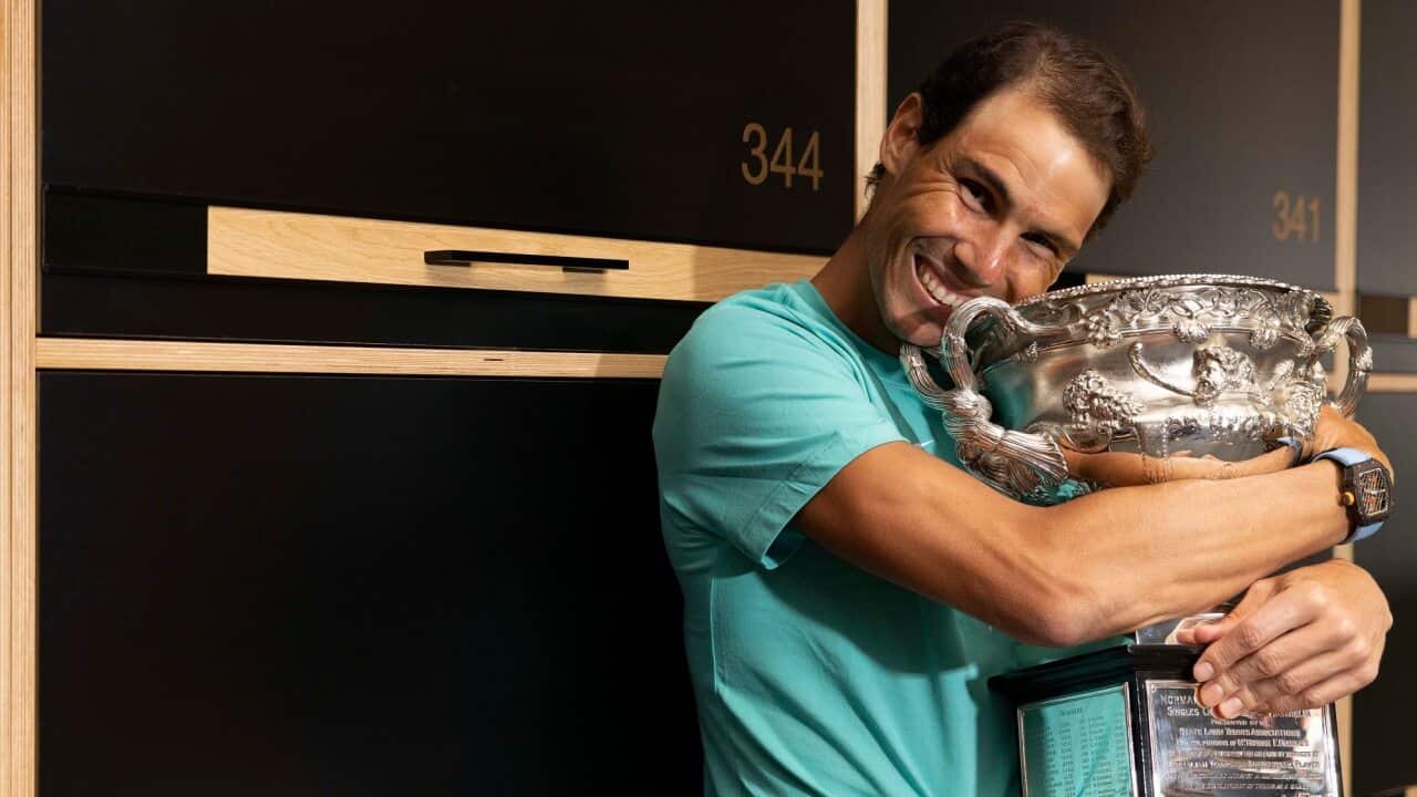 Rafael Nadal poses with his 21st grand slam trophy after winning the 2022 Australian Open men's singles title.