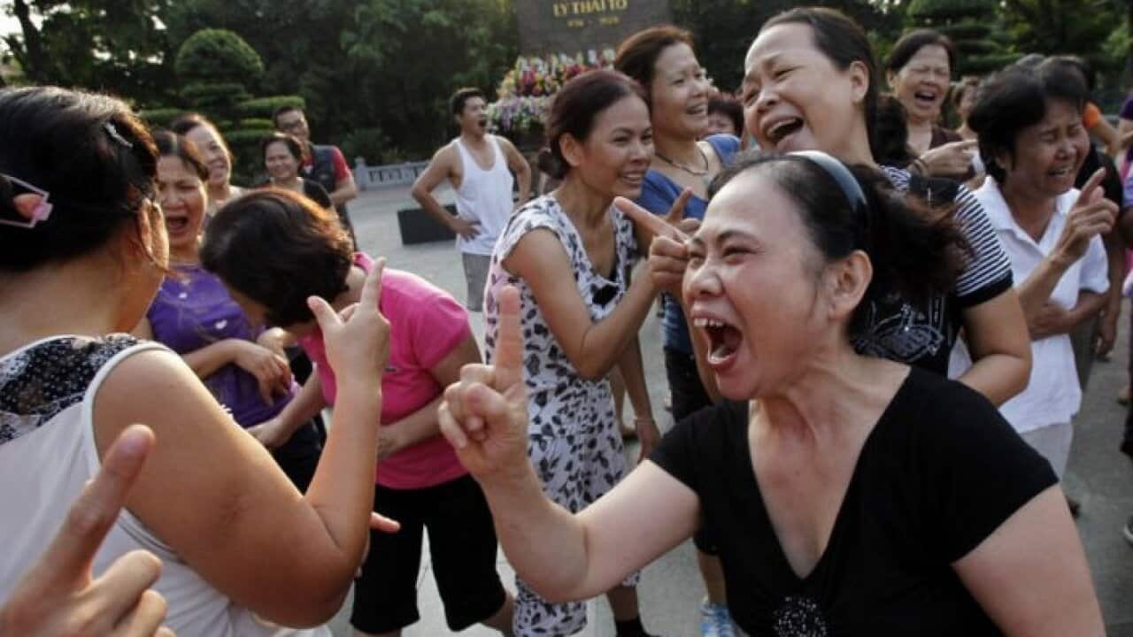 Members of the Laughter Yoga club practise laughing during morning exercise at a public park in Hanoi.