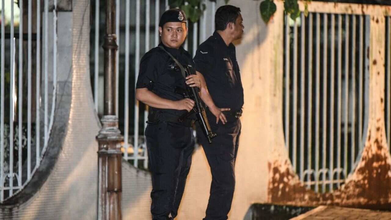Malaysian police officers stand at the entrance of the former Prime Minister Najib Razak's residence in Kuala Lumpur.