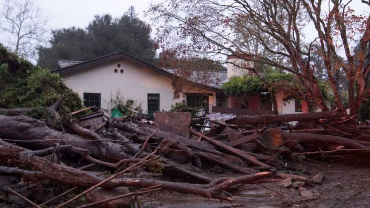 A home seen surrounded by flooded water and debris after a mudslide in California